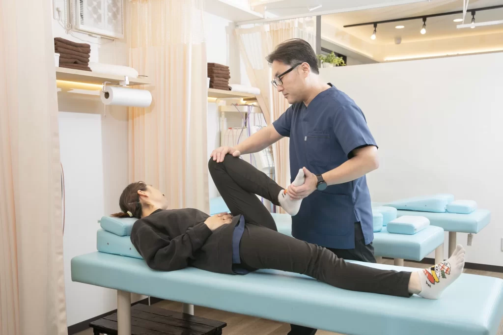 横須賀市の鍼灸整骨院ひまわりで仙腸関節痛の見立てに向けて股関節と骨盤周りの動きを確認している評価の様子