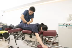 横須賀市のぎっくり腰、トムソンテーブルで負担の少ない骨格バランス調整を行う施術風景
