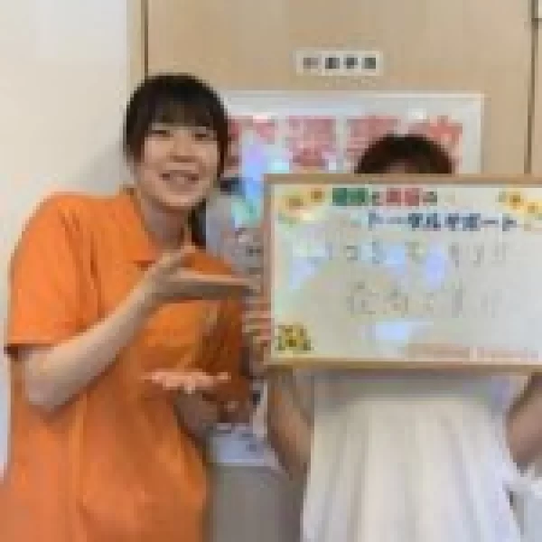 横須賀市の鍼灸整骨院ひまわり北久里浜院で、患者様が「いつもスッキリ!! 最高です!!」と書かれたボードを持ち、スタッフが隣で指し示している様子