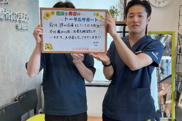 患者様の声:「回旋腱板損傷」(左肩の痛み)が改善|鍼灸整骨院ひまわり北久里浜院(横須賀市) 横須賀市の鍼灸整骨院ひまわり北久里浜院で、「回旋腱板損傷」(左肩の痛み)が「大分良くなってきています!!」と書かれたボードを掲げる施術者と患者様の様子。