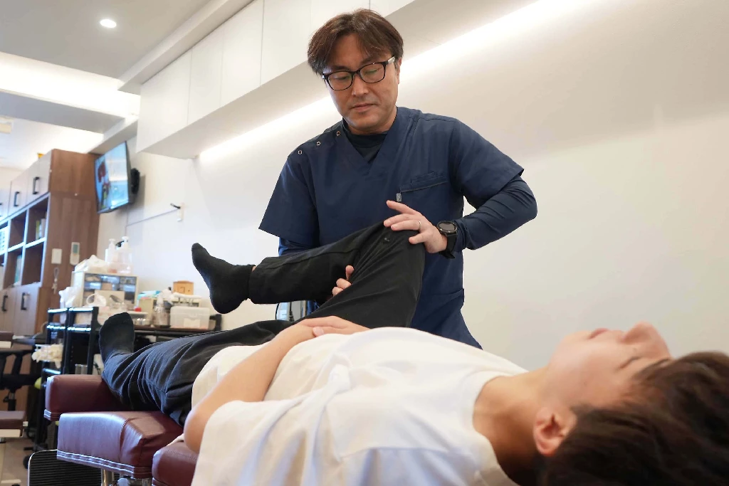 【横須賀市】ランニング・部活で痛む「シンスプリント」の根本改善専門施術 | 鍼灸整骨院ひまわり 横須賀市の鍼灸整骨院ひまわりで、施術者がシンスプリントの根本原因である股関節・骨盤の歪みを検査している様子