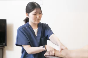 横須賀の鍼灸整骨院ひまわりで、女性施術者がCM関節炎による親指の付け根の痛みに対応するため、手首や関節に対し手技で丁寧に施術を行っている様子