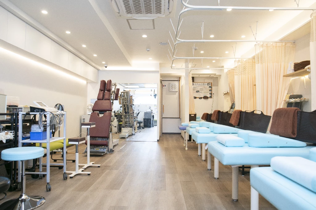 横須賀市の鍼灸整骨院ひまわり北久里浜院の施術室全景、施術ベッドと施術機器が並ぶ院内写真