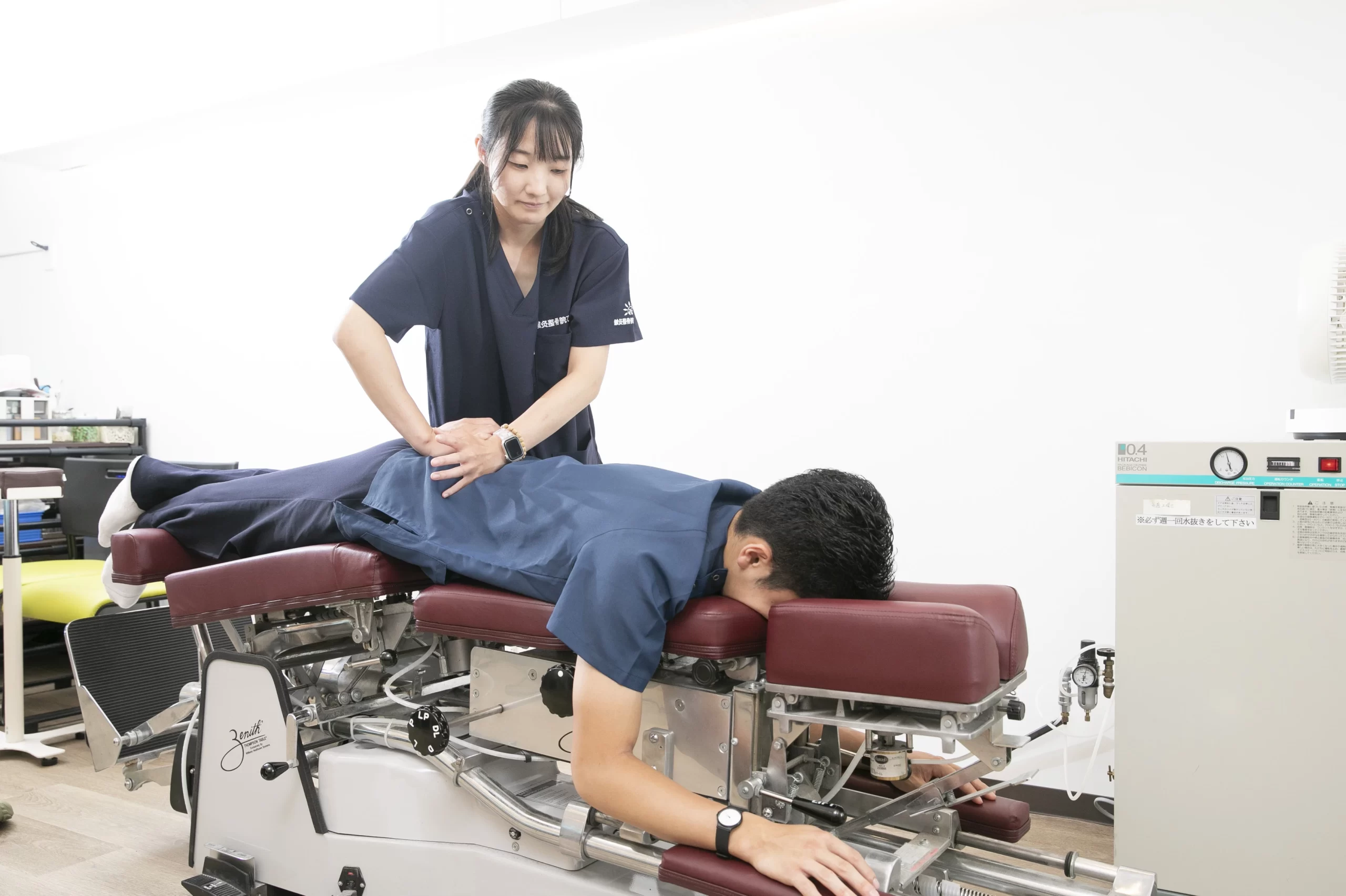 ランナー腰痛に対する状態確認と施術の様子 トムソンテーブルで日本人男性ランナーの骨盤と腰の状態を確認する施術風景