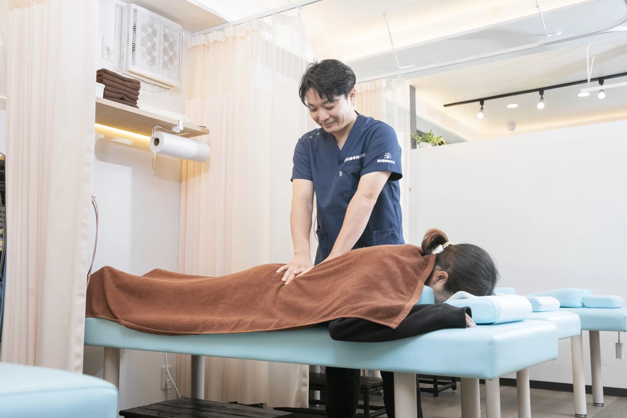 テニス中の腰痛に対する評価と施術の流れ 鍼灸整骨院ひまわりでテニス選手の腰を確認する施術イメージ