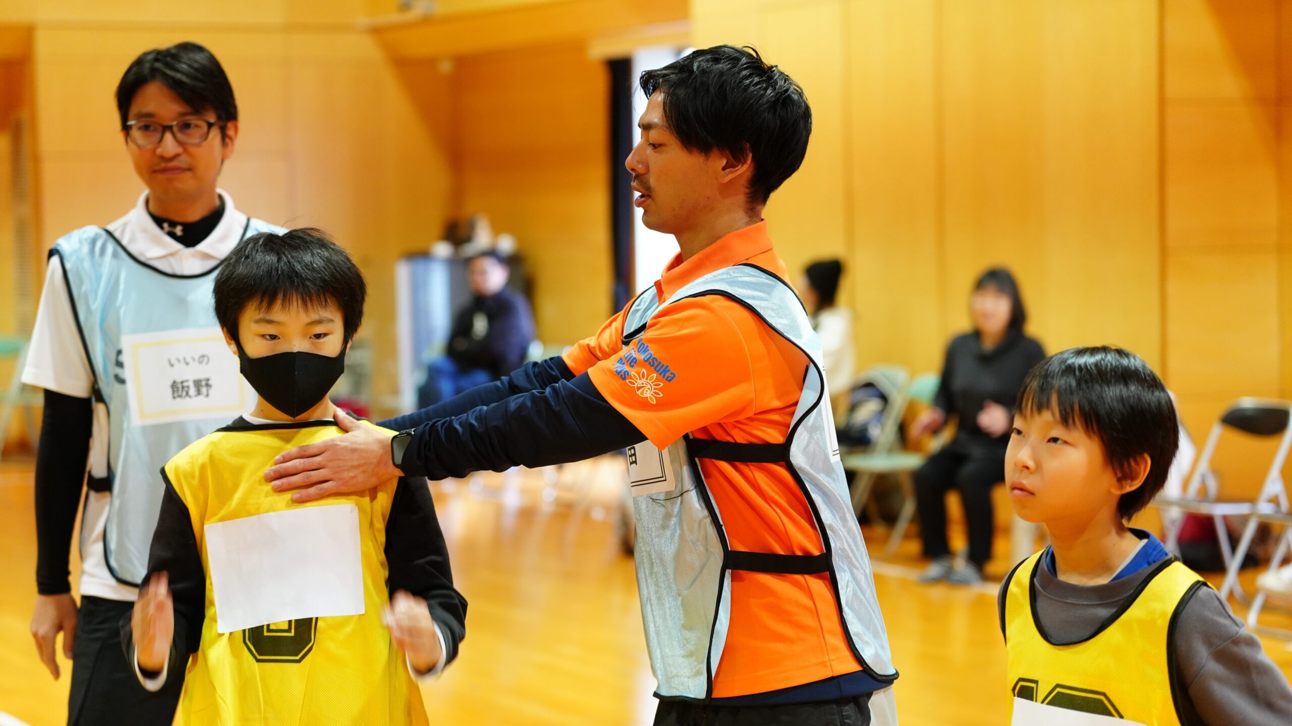 かけっこ教室で講師が子どもに姿勢や体の使い方を丁寧に指導している様子