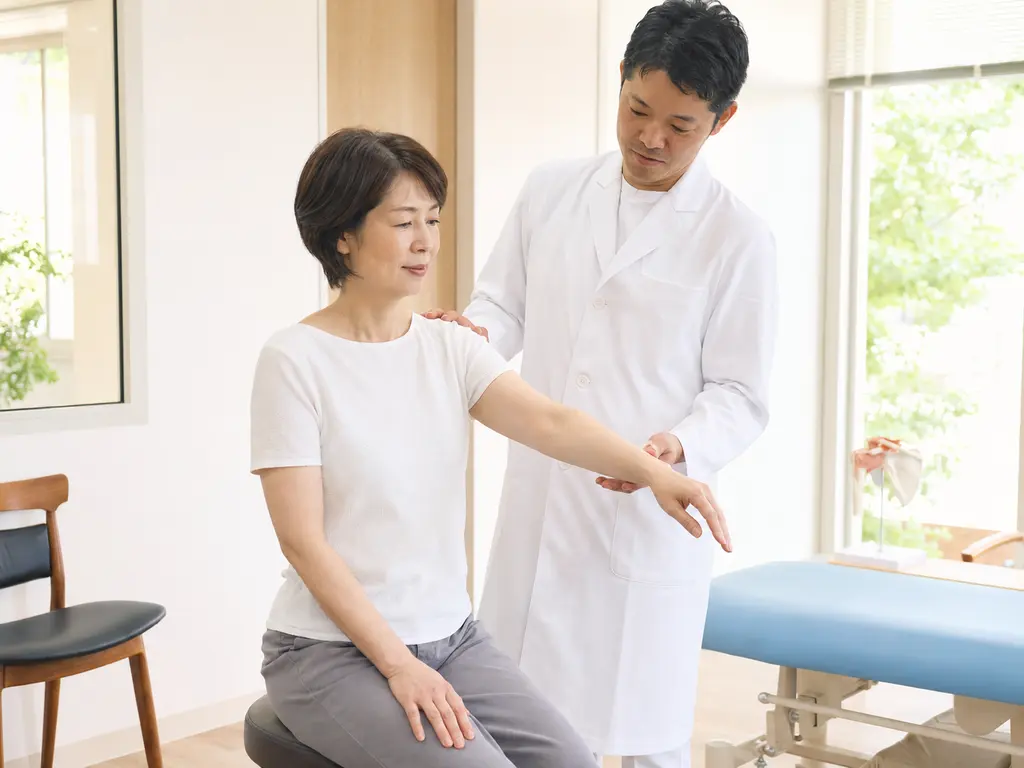 肩と肩甲骨の動作確認 四十肩・五十肩に関連する肩、肩甲骨、腕、体幹の動きを施術者が無理のない範囲で確認する様子